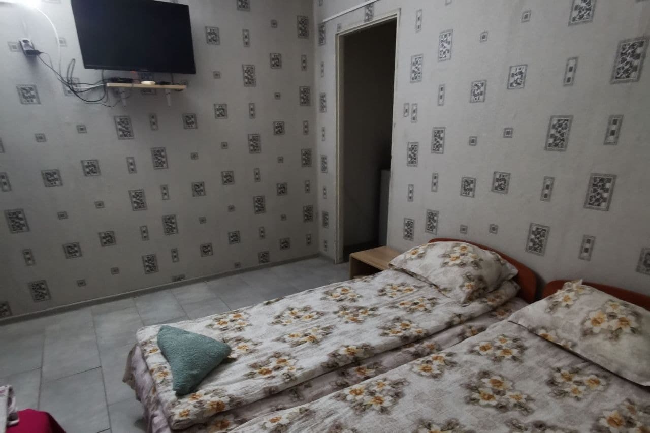 Спалня с геометрични тапети и телевизор